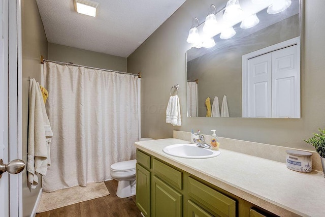 bathroom with toilet, wood finished floors, vanity, and a shower with curtain