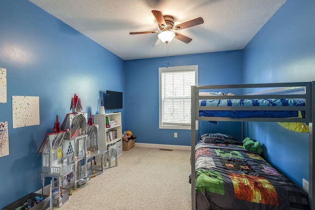 carpeted bedroom featuring a textured ceiling, baseboards, and a ceiling fan