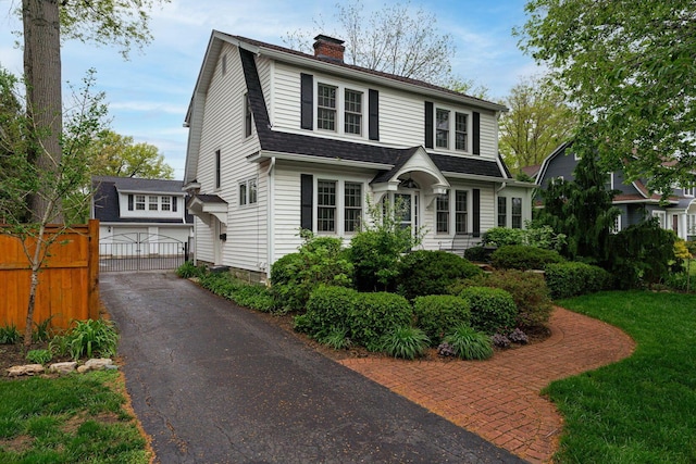 2842 Powell Ave, Columbus, OH 43209 - dutch colonial featuring a garage, a chimney, a shingled roof, a gambrel roof, and driveway