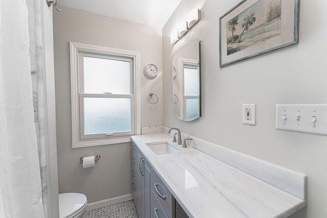 2842 Powell Ave, Columbus, OH 43209 - full bathroom featuring vanity, toilet, baseboards, and a textured ceiling