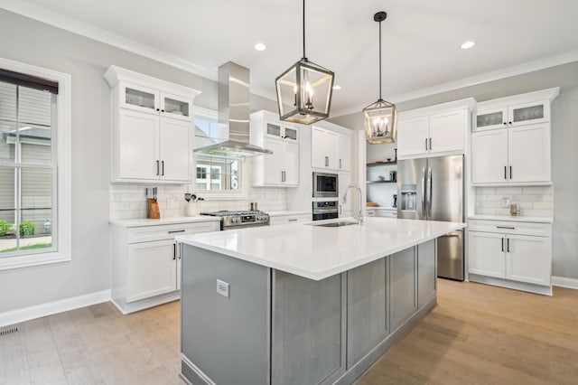 kitchen with stainless steel appliances, range hood, a sink, tasteful backsplash, and a center island with sink
