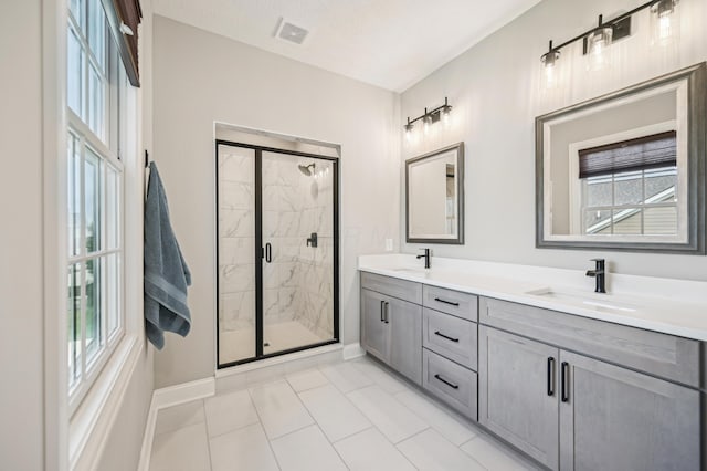 bathroom featuring baseboards, plenty of natural light, a shower stall, and double vanity