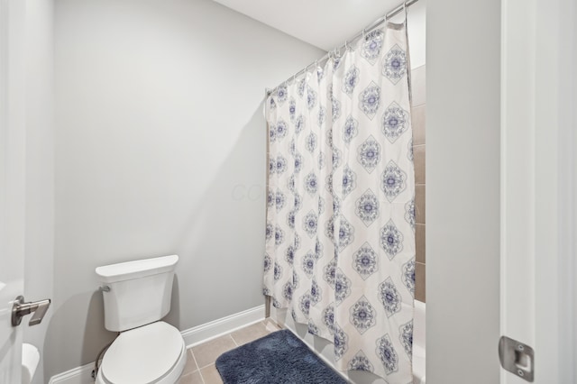 bathroom with toilet, shower / bath combo, tile patterned flooring, and baseboards
