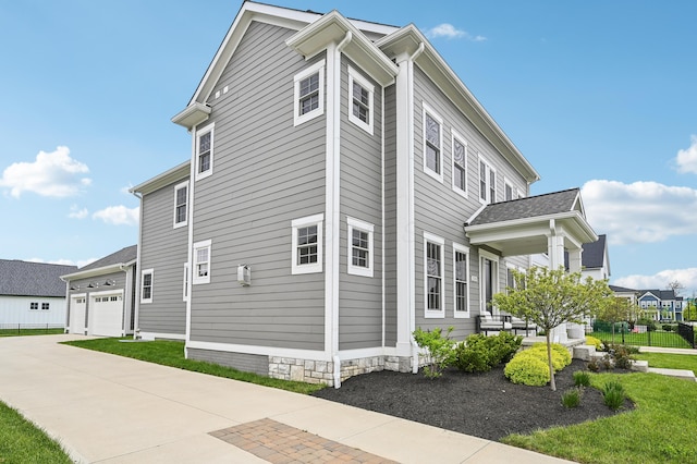 view of side of home featuring driveway and an attached garage