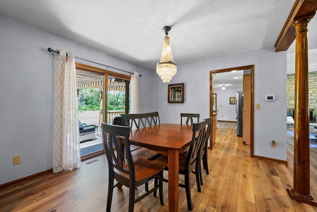 6730 Tussic Rd, Westerville, OH 43082 - dining area with light wood finished floors, a chandelier, baseboards, decorative columns, and a textured ceiling