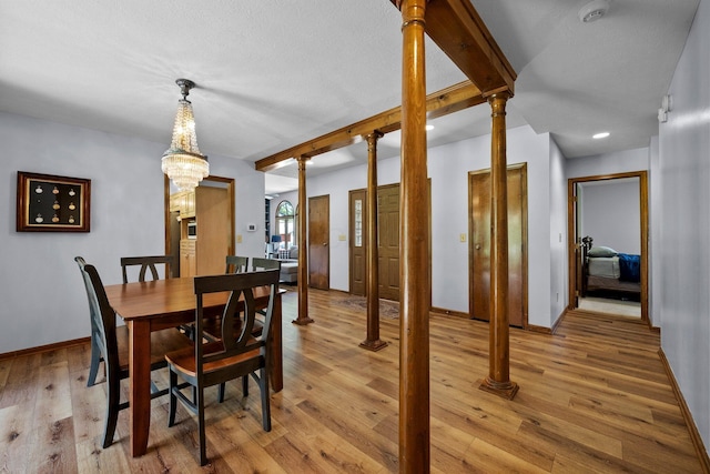 6730 Tussic Rd, Westerville, OH 43082 - dining space featuring beamed ceiling, baseboards, light wood-style flooring, a chandelier, and ornate columns