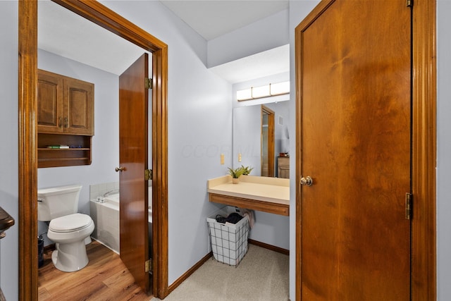 6730 Tussic Rd, Westerville, OH 43082 - full bathroom featuring toilet, a garden tub, wood finished floors, and baseboards