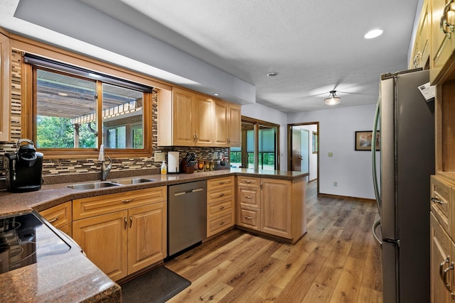 6730 Tussic Rd, Westerville, OH 43082 - kitchen featuring appliances with stainless steel finishes, a sink, tasteful backsplash, a peninsula, and light wood-style flooring