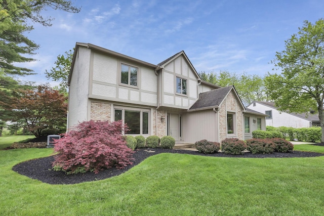 tudor home with stucco siding and a front yard