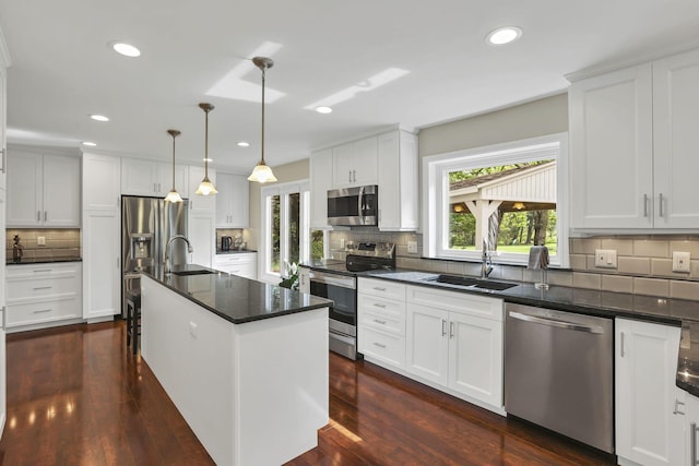 kitchen featuring a sink, backsplash, dark wood-type flooring, and appliances with stainless steel finishes