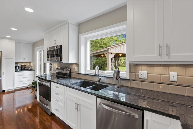 kitchen with recessed lighting, a sink, dark wood-type flooring, stainless steel appliances, and tasteful backsplash