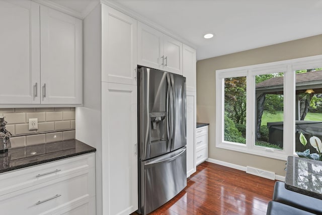 kitchen featuring stainless steel fridge with ice dispenser, dark wood finished floors, visible vents, baseboards, and white cabinetry