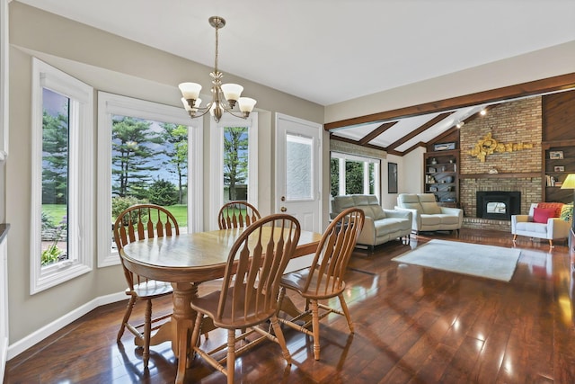 dining room featuring baseboards, a chandelier, dark wood-type flooring, lofted ceiling with beams, and a fireplace