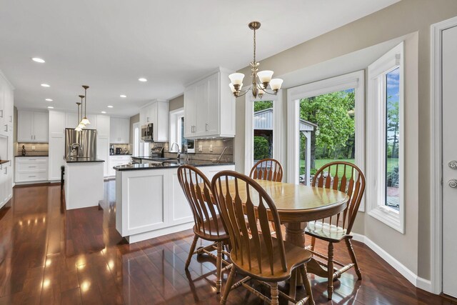 dining space featuring recessed lighting, a notable chandelier, baseboards, and dark wood finished floors