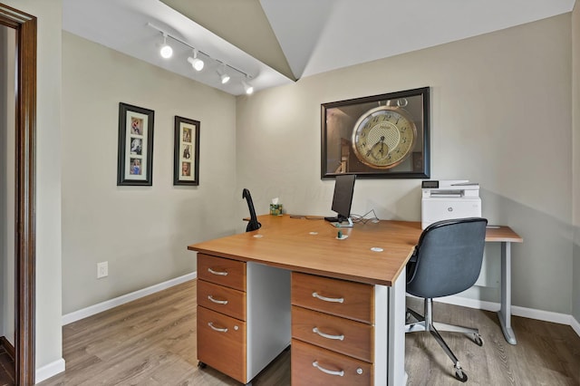 office space with baseboards, light wood-style flooring, and track lighting