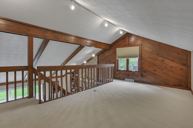 additional living space featuring vaulted ceiling, carpet flooring, wood walls, and visible vents