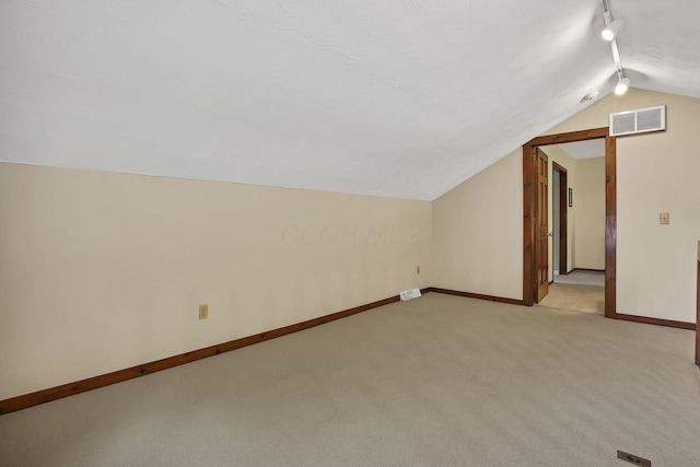 bonus room with vaulted ceiling, light carpet, baseboards, and visible vents