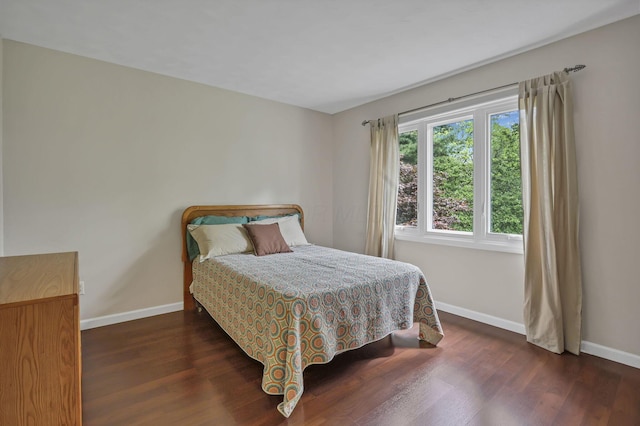 bedroom with baseboards and wood finished floors