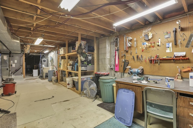 basement featuring heating unit, water heater, and a workshop area