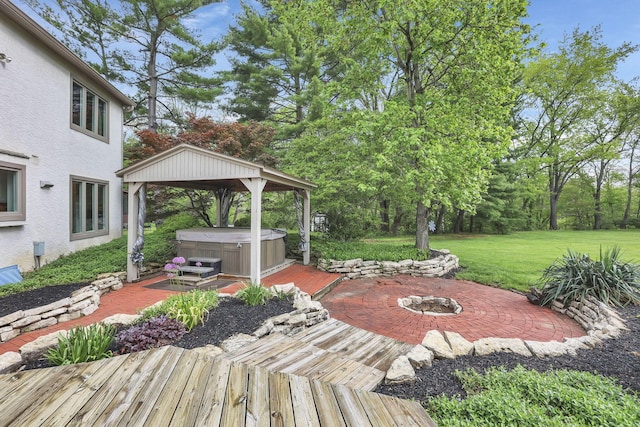 exterior space with a hot tub, a gazebo, and a fire pit