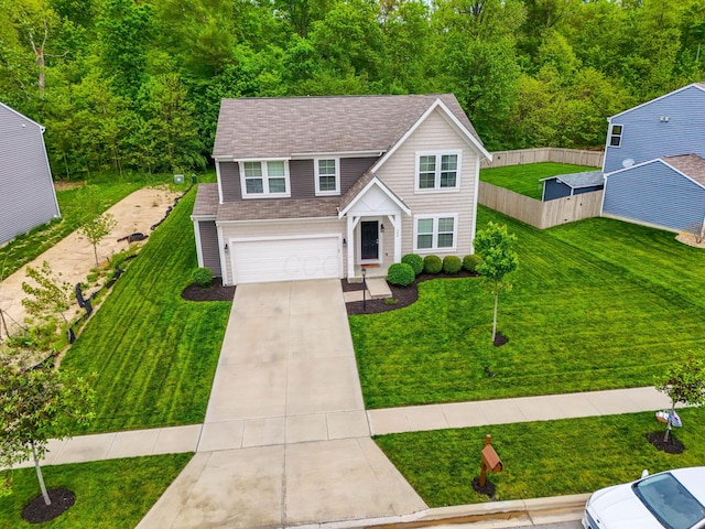 traditional-style house with concrete driveway, an attached garage, and roof with shingles