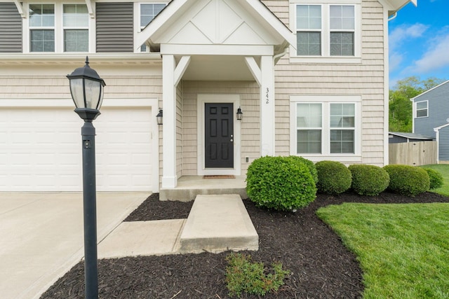 property entrance with concrete driveway and a garage