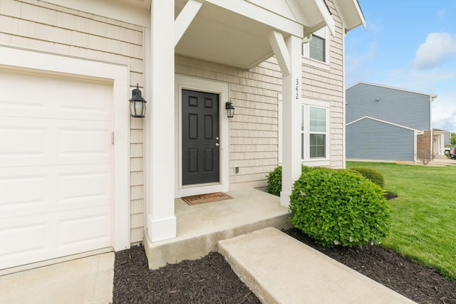 property entrance with a garage and a lawn
