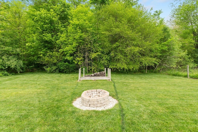 view of grassy yard with a fire pit