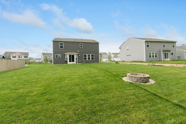 rear view of property with a fire pit and a residential view