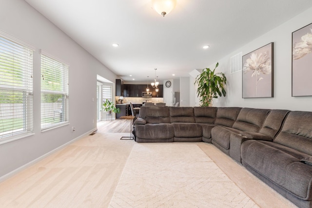 living area featuring recessed lighting, baseboards, a chandelier, and light colored carpet