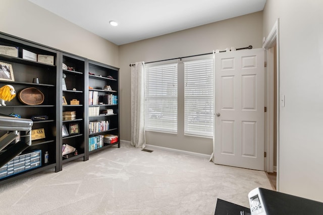 living area featuring light colored carpet and baseboards