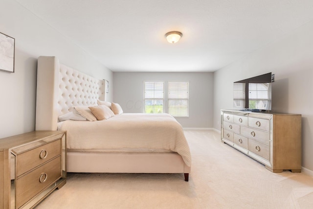 bedroom featuring light colored carpet, multiple windows, and baseboards