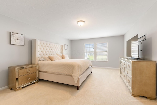 bedroom featuring light colored carpet and baseboards
