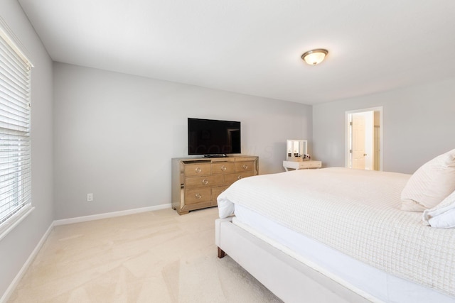 bedroom featuring light carpet and baseboards
