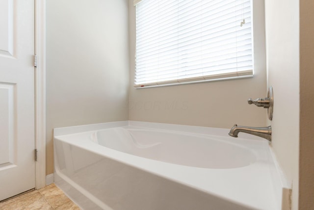 bathroom featuring plenty of natural light and a bath