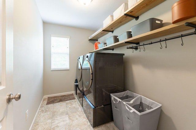 clothes washing area featuring washing machine and dryer and baseboards