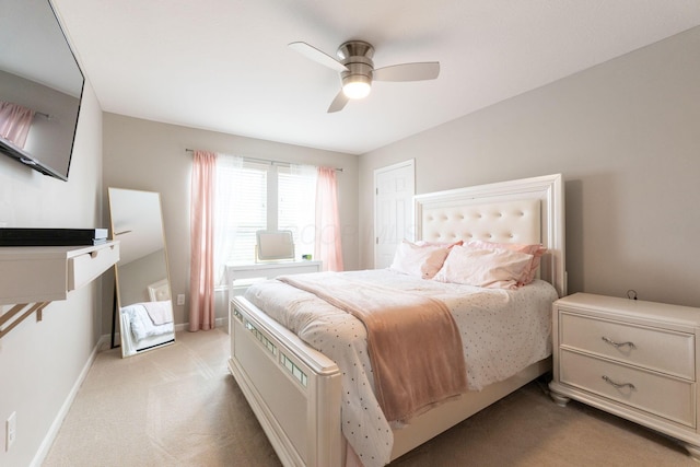 bedroom featuring light colored carpet, baseboards, and a ceiling fan
