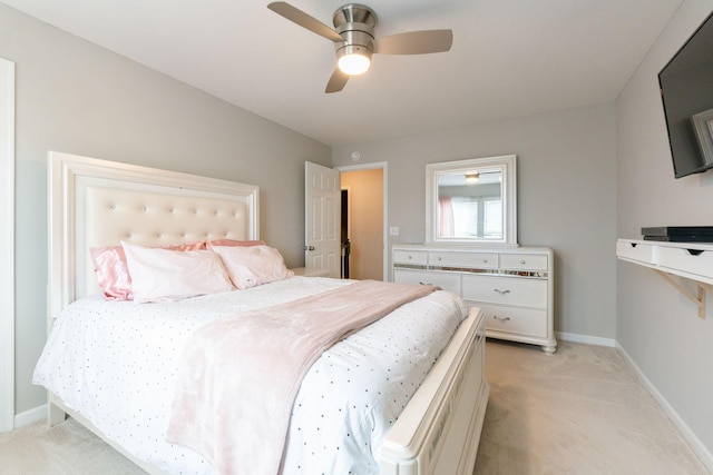 bedroom featuring light colored carpet, baseboards, and ceiling fan