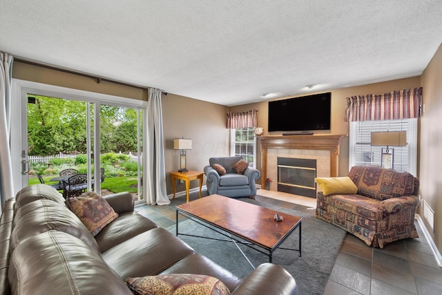 670 Mill Wood Blvd, Marysville, OH 43040 - living area featuring a tile fireplace, a textured ceiling, and baseboards