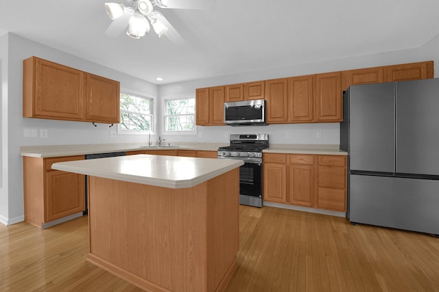 7553 Indian Creek Way, Powell, OH 43065 - kitchen with appliances with stainless steel finishes, light wood-style floors, light countertops, a ceiling fan, and a center island