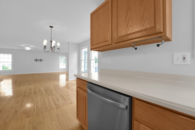 7553 Indian Creek Way, Powell, OH 43065 - kitchen with stainless steel dishwasher, a chandelier, open floor plan, light countertops, and light wood-type flooring