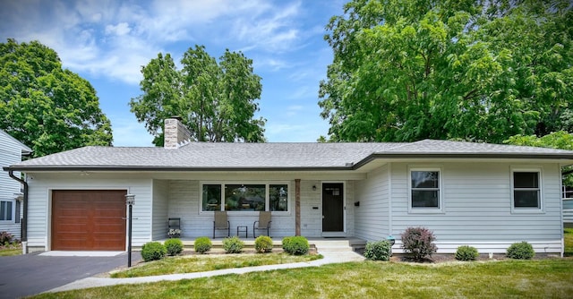 single story home featuring a chimney, driveway, covered porch, an attached garage, and a front lawn