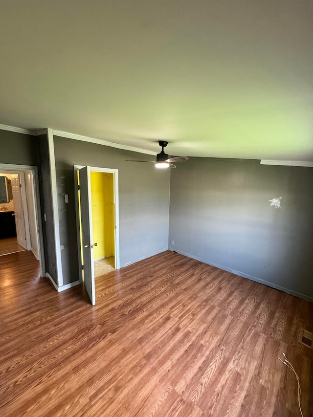 unfurnished bedroom with crown molding, wood finished floors, and baseboards
