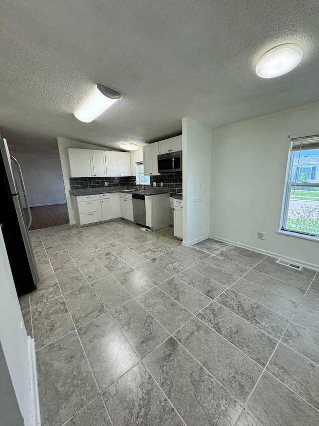 kitchen featuring a textured ceiling, white cabinetry, visible vents, and appliances with stainless steel finishes