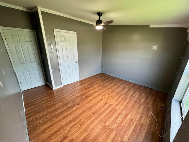 unfurnished bedroom with crown molding, baseboards, ceiling fan, and wood finished floors