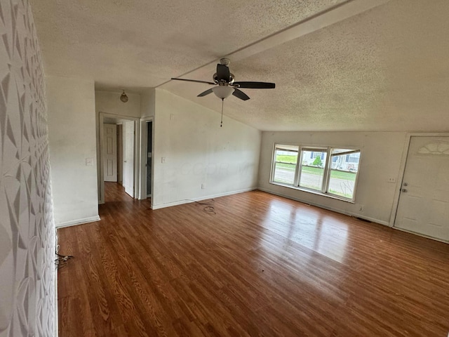 unfurnished living room featuring wood finished floors, a textured ceiling, vaulted ceiling, ceiling fan, and baseboards