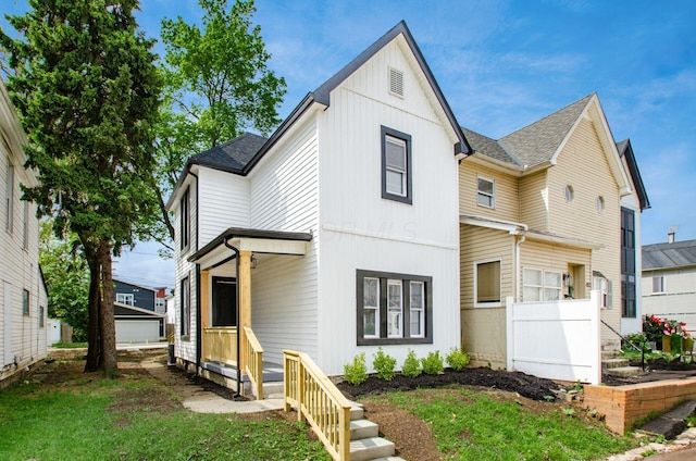 modern inspired farmhouse featuring roof with shingles