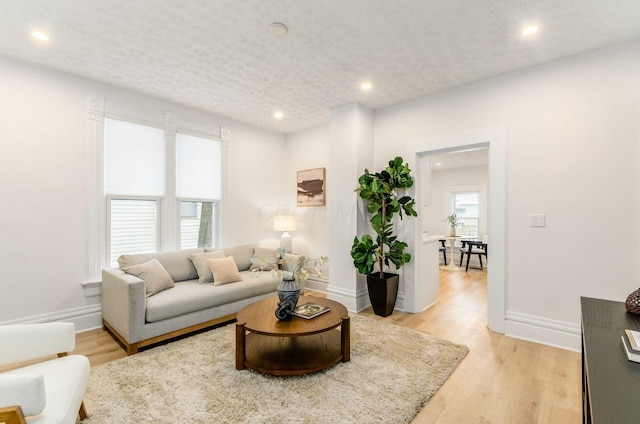 living area featuring baseboards and recessed lighting