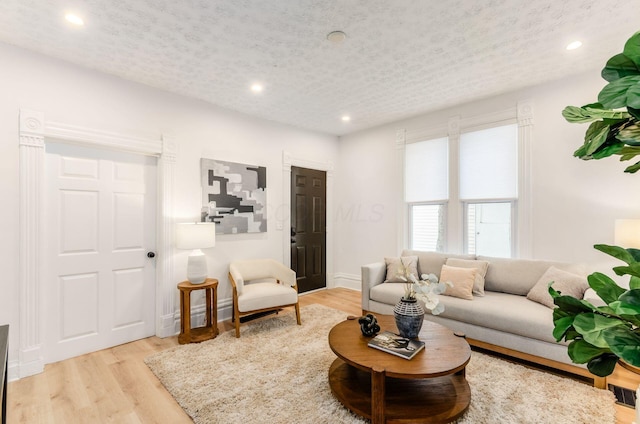 living area with baseboards, recessed lighting, and wood finished floors