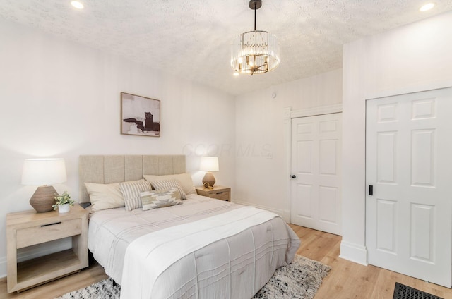 bedroom featuring visible vents, a chandelier, recessed lighting, and light wood-style flooring